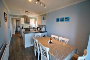 kuchnia i jadalnia ze stołem i krzesłami w obiekcie Sandy Sorlands Beach House- stunning seaside home w mieście Anstruther