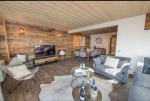a living room with a couch and a table at Chalet 2 sur la route du tour in LʼHuez