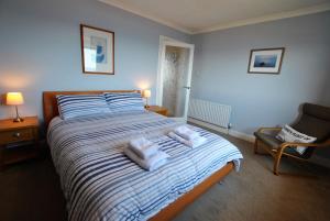 una camera da letto con un letto e asciugamani di Sandy Sorlands Beach House- stunning seaside home a Anstruther