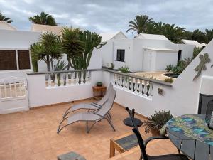una casa con balcón con sillas y plantas. en One bedroom bungalow Playa Bastian Costa Teguise, en Costa Teguise