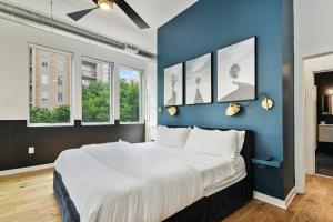 a bedroom with a blue wall with a bed and windows at Equidistant Of World Famous Piedmont Park Luxury King Bed in Atlanta