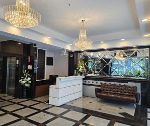 a lobby with a bench and chandeliers at Ritz Boutique Hotel in Pattaya South