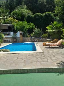 uma piscina com uma cadeira ao lado de um resort em la Vega Fuente las moreras em La Iruela