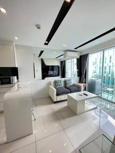 a living room with a couch and a table at City Center Residence - Pool view in Pattaya Central