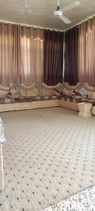 a room with two beds and a curtain at Marmr in Abū Turābah
