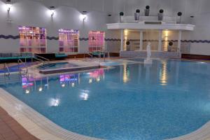 a large swimming pool with a fountain in a building at Belton Woods Hotel, Spa & Golf Resort in Grantham