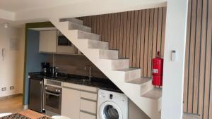 een keuken met een trap en een wasmachine bij Miras Apartment Ushuaia in Ushuaia