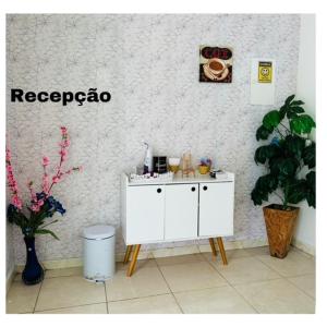 un bancone bianco in una stanza con piante di Hostel das Flores a Belém