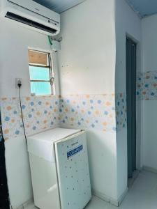 a small kitchen with a refrigerator in a room at Hostel das Flores in Belém