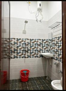 uma casa de banho com um chuveiro, um WC e um lavatório. em Lotus Paying Guest house em Varanasi