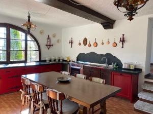 eine Küche mit einem Holztisch und roten Schränken in der Unterkunft Chalet Miralago in Plesio