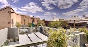 een balkon met een bank en een parasol bij Riad Dar Chacha in Marrakesh