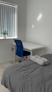 a desk and a bed with a desk and a chair at Luxury Rooms in a 3-Bedroom House, Living Room, Kitchen, Big garden only 8mins away from Coventry City Centre in Coventry