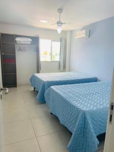 2 camas en una habitación de hotel con sábanas azules en Golden Lake Arraial do Cabo Resort, en Arraial do Cabo