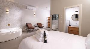 a bathroom with a bed and a tub and a sink at 49 Boutique in Zikhron Ya'akov