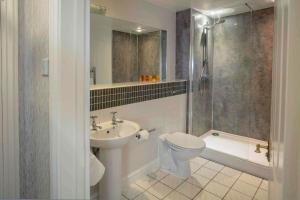 a bathroom with a toilet and a sink and a shower at Old Hunstanton Le Strange Arms Hotel in Hunstanton +37 photos
