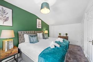 a bedroom with a large bed and green walls at Camden Cottage, 2 Bedroom house in Camden Town in London