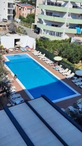 a large swimming pool with lounge chairs and a building at Monty studio in Bar