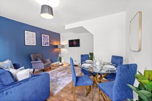 a dining room with blue chairs and a table at Camden Cottage, 2 Bedroom house in Camden Town in London