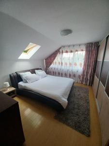 a bedroom with a large white bed and a window at Vila Gloria ,Brașov in Ghimbav