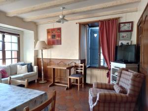 ein Wohnzimmer mit einem Sofa und einem Tisch in der Unterkunft la Maison d'Odette et Daniel in Vitrac