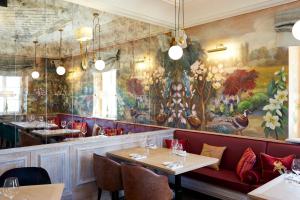 a restaurant with a large painting on the wall at Bel Mon Resort in Rybnik