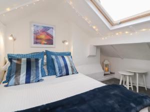 a bedroom with a large bed with blue and white pillows at Kitty Cottage in Blackpool