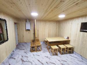 a room with a wooden table and benches in a room at 5-комнатный дом посуточно in Shymkent