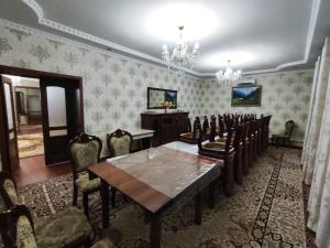 een eetkamer met een tafel en stoelen en een kroonluchter bij 5-комнатный дом посуточно in Simkent