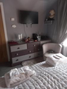 a bedroom with a bed and a dresser with towels on it at The Boat House BED ONLY NO BREAKFAST in Aultbea +1 photo