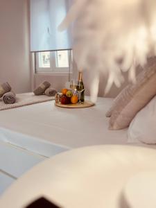a table with a plate of fruit and a bottle of champagne at Cactus Luxury suite1 in Athens