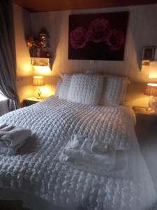 Un dormitorio con una cama blanca con toallas. en The Boat House BED ONLY NO BREAKFAST, en Aultbea