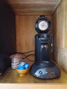 a coffee maker sitting on a counter with a clock at East Meets West Bed and Breakfast in Veenendaal