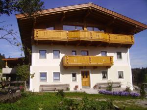 ein großes weißes Gebäude mit einem Holzbalkon in der Unterkunft Obereinschneithof in Schwendt