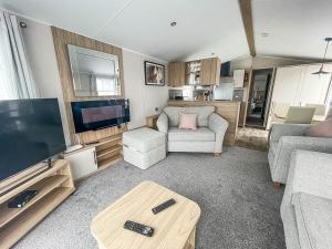 a living room with a large flat screen tv at Beautiful 6 Berth Caravan With Decking, Wifi And Field Views Ref 29029sv in Clacton-on-Sea