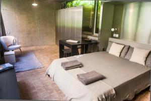 a bedroom with a large bed and a desk at Fàbrica Descals and Pavillion in Olot