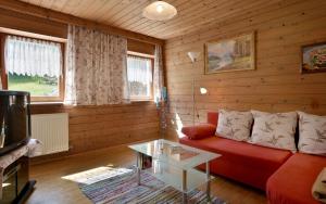 ein Wohnzimmer mit einem roten Sofa und einem Tisch in der Unterkunft Obereinschneithof in Schwendt