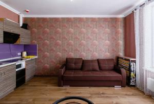 ein Wohnzimmer mit einer braunen Couch in einer Küche in der Unterkunft Kvartirkoff na Bogatyrskaya 6a, 15th floor in Kiew + 5 Fotos