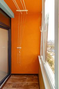 ein Raum mit einer orangefarbenen Wand und einem Fenster in der Unterkunft Kvartirkoff na Bogatyrskaya 6a, 15th floor in Kiew