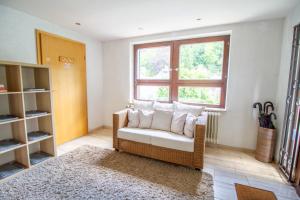 - un salon avec une chaise en osier et une fenêtre dans l'établissement Ferienhaus Mühlenberg, à Monschau