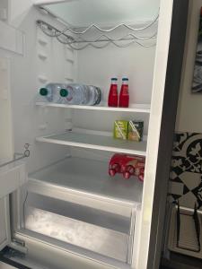 a refrigerator with its door open with drinks and water bottles at Viscalori Homes in Viagrande