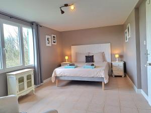 ein Schlafzimmer mit einem großen Bett mit zwei Lampen in der Unterkunft Gîte Coursaint-Pierre in Paulhiac