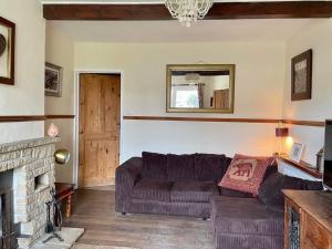 a living room with a couch and a fireplace at Pilgrims Rest with Annexe in Cheddar
