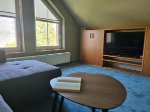 a living room with a couch and a table and a tv at Ferienwohnung Am Helderbach 