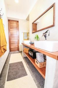 a bathroom with a white sink and a mirror at Babu Villas in Jambiani