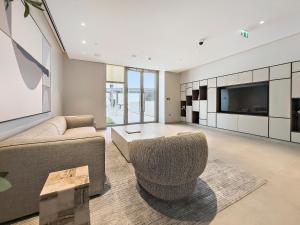 ein Wohnzimmer mit einem Sofa und einem TV in der Unterkunft WelHome - Stunning Apartment With Sea Views in Creek Harbour in Dubai