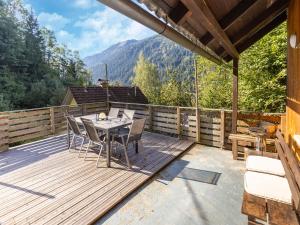 a wooden deck with a table and chairs on it at Holiday apartment in Feld am See in Carinthia in Feld am See