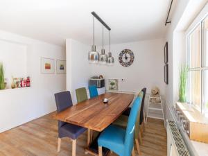 uma sala de jantar com uma mesa de madeira e cadeiras azuis em Holiday apartment in Feld am See in Carinthia em Feld am See