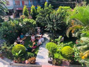 a group of people sitting in a garden at Hotel Guru in Pokhara
