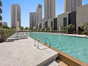 ein Schwimmbad in einer Stadt mit hohen Gebäuden in der Unterkunft WelHome - Stunning Apartment With Sea Views in Creek Harbour in Dubai